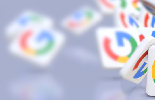 Google company logos fall on a table. Banner format with copy space and selective focus.
