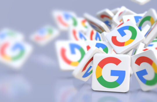 Google company logos fall on a table. Banner format with copy space and selective focus.