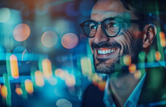 Happy successful trader smiling with stock market graph charts