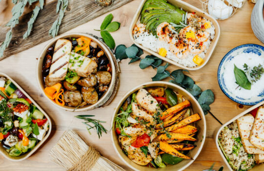 Various healthy and vitamin-rich dishes and food in an ecobox delivered by a delivery service, ordered online, decorated with bundles of straw, mussels and cacti, in a Mediterranean style