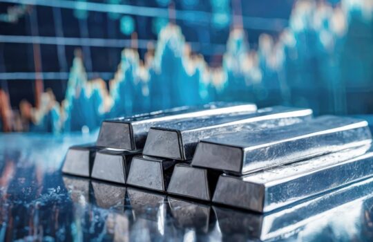 Precious metals forming a pyramid reflect on a sleek, modern trading surface. Bars of silver create a monument to wealth amidst the backdrop of market dynamics..