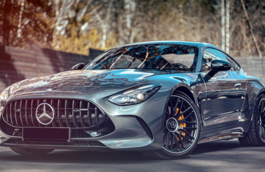 Novosibirsk, Russia - April 23, 2024 : silver Mercedes-Benz AMG GT 63 S 4MATIC , front view, against city in summer time