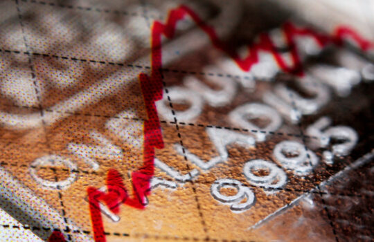 Close-up of a palladium bar and positive stock market trend-line