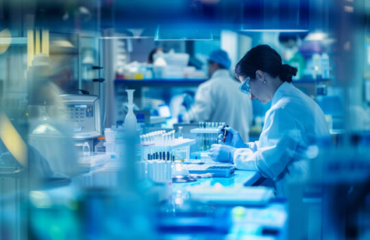 A soft-focus image of medical professionals working in a laboratory, analyzing data and conducting experiments