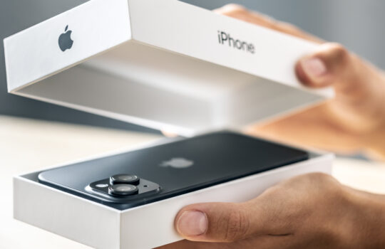 Prague Czech Republic: September - 09 - 2024: A customer in an Apple Store holds a new iPhone smartphone in a box.