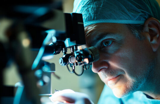A skilled eye doctor focuses intently on a male patient while conducting laser vision correction using advanced instruments in a medical environment