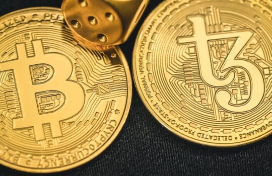 two gold bitcoins sitting next to each other