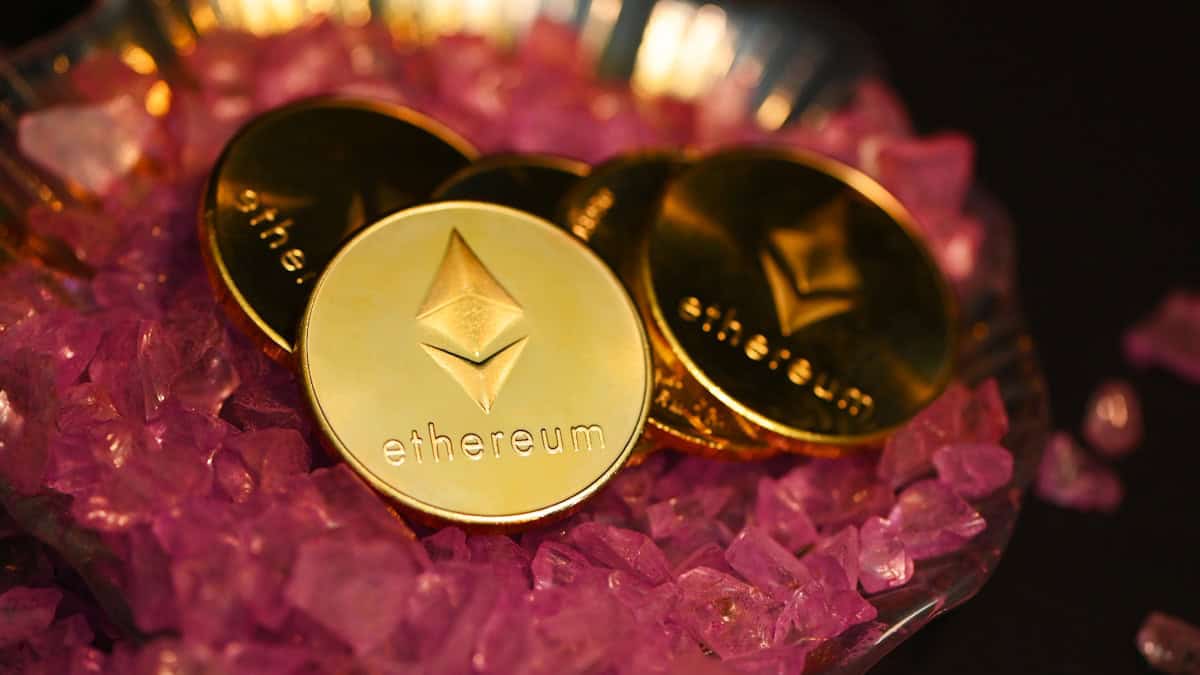 two gold coin sitting on top of a pile of pink crystals