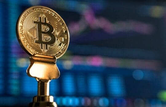 selective focus photo of Bitcoin near monitor