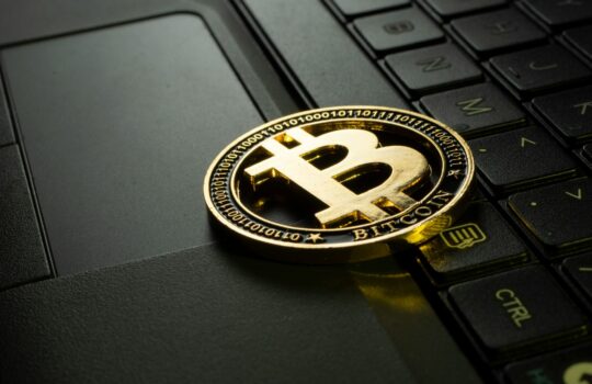 Bitcoin Münze auf einem Laptop