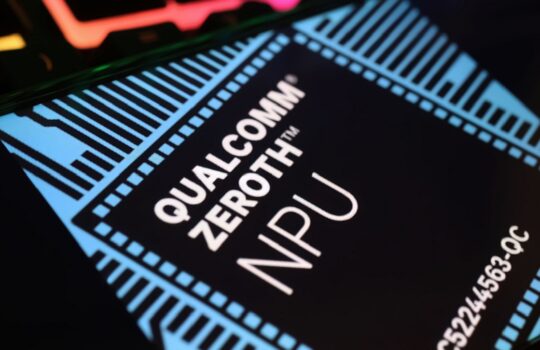 Close-up of a circuit board chip with a blue border and the text 'QUALCOMM ZERO TRUST NPU' in white letters on a dark background, conveying a high-tech processor image.