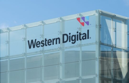 Glass building façade displaying the Western Digital logo and name with a blue sky backdrop (corporate storefront/entrance signage).