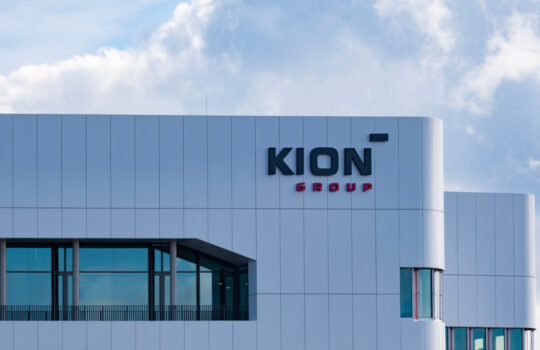 Modern white office building with the KION Group logo on the facade.