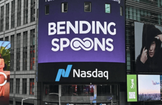 Large purple billboard reading 'Bending Spoons' above the Nasdaq logo on a tall building in a busy urban area (Times Square setting).