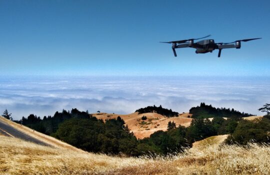 black drone on air over cloudy sky at daytime