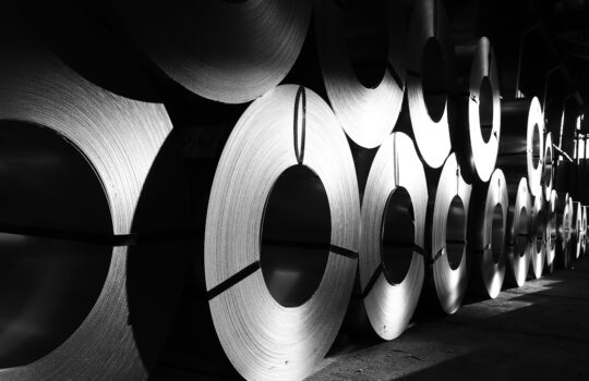 rolls of steel are lined up in a warehouse
