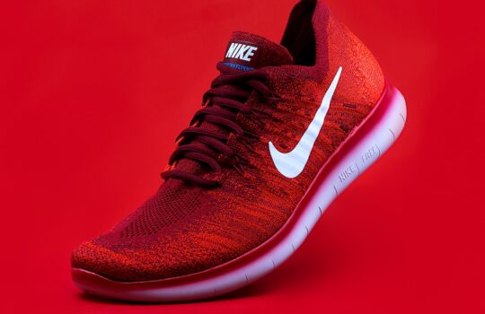 unpaired red Nike sneaker