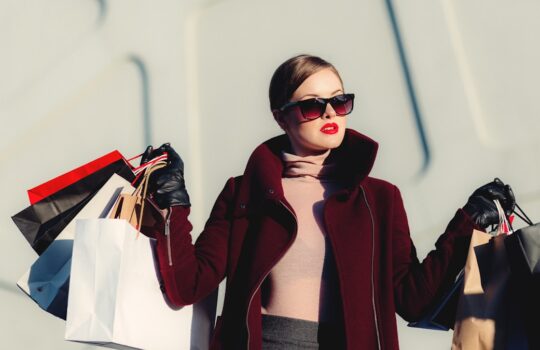 photo of woman holding white and black paper bags