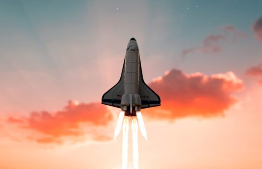 A space shuttle launching into a starry sky above a field at golden hour