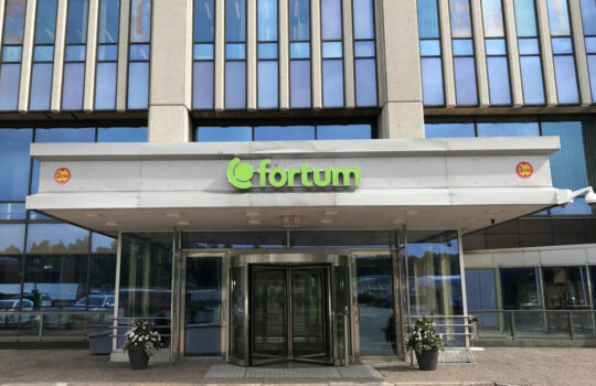Fortum storefront entrance with glass doors and a green Fortum logo