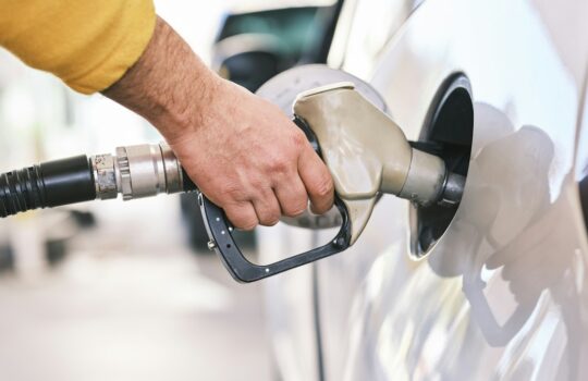a man pumping gas into his car at a gas station