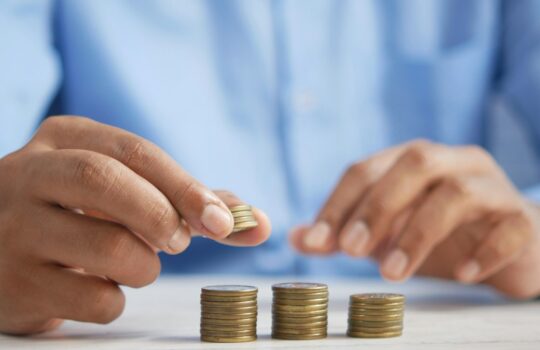 a person stacking coins on top of a table