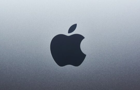 A dark apple logo centered on a smooth grey metallic surface