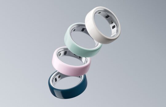 Five pastel-colored smart rings stacked diagonally against a gray background.